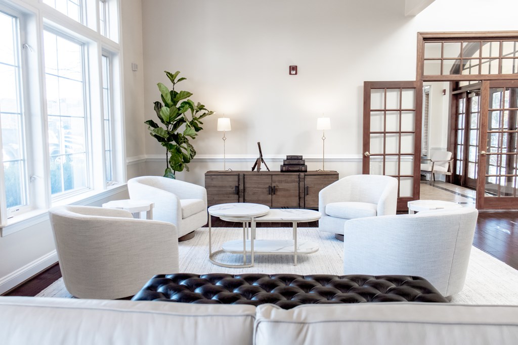 a living room with white furniture and large windows at Broadlands Apartments, 20148